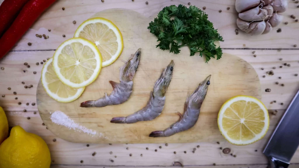 tiga udang dengan lemon di atas talenan